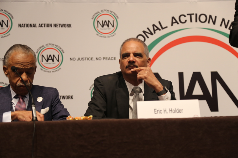 Former Attorney General Eric Holder sits with the Rev. Al Sharpton at the National Action Network Convention in New York City on April 18, 2018.